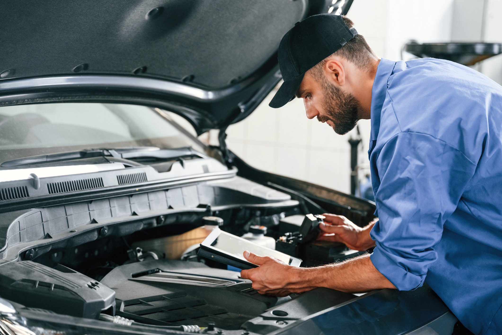 Auto mechanic checking car engine