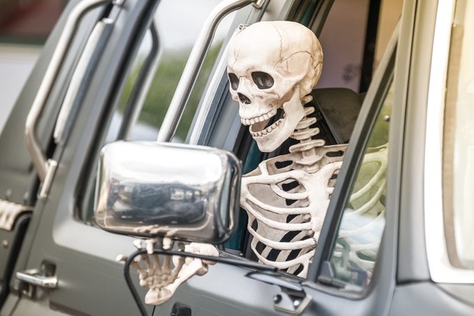 Human Skeleton Halloween Decoration Hanging out of Window of a Truck