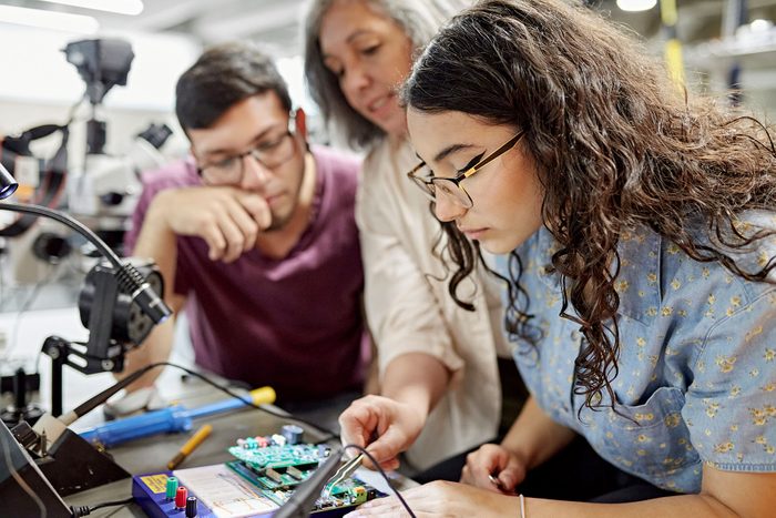 College instructor assisting electrical engineering students