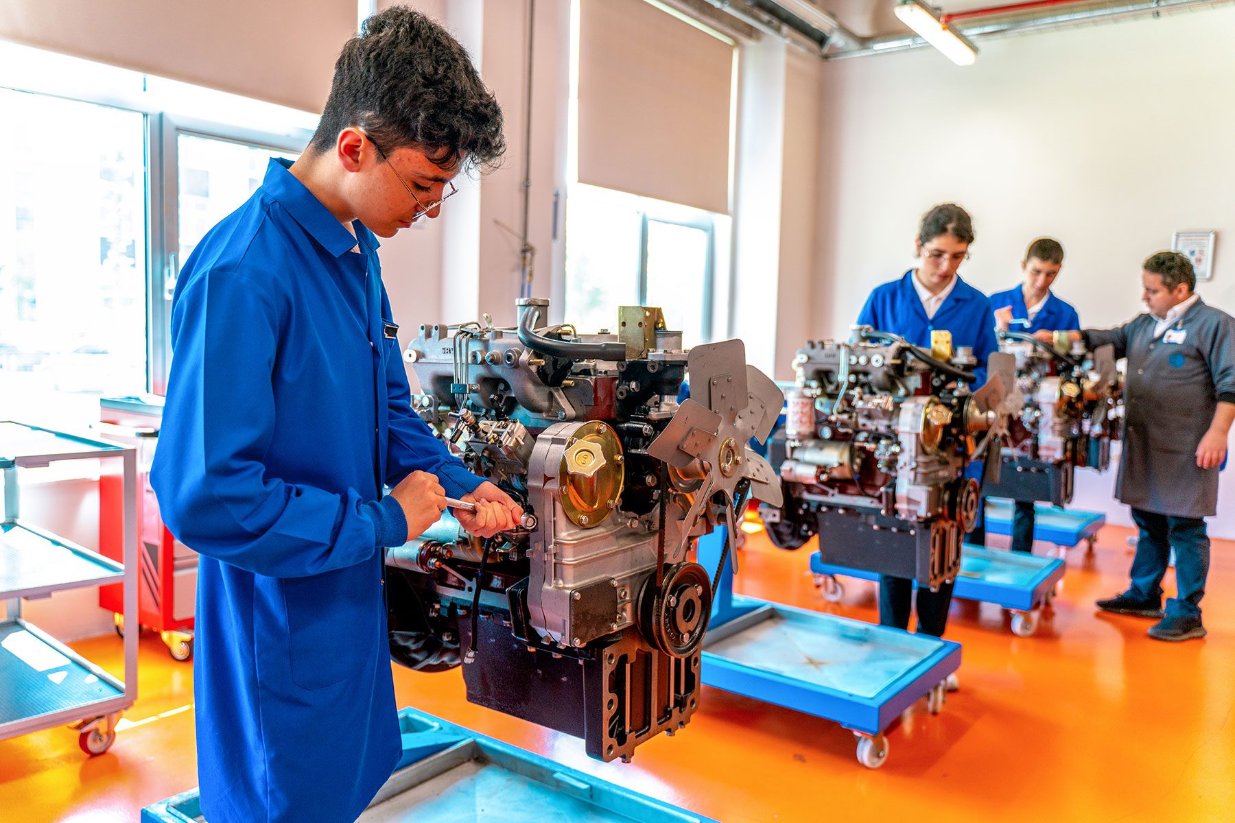 Group Of Students Studying For Auto Mechanic Apprenticeship At Vocational Education