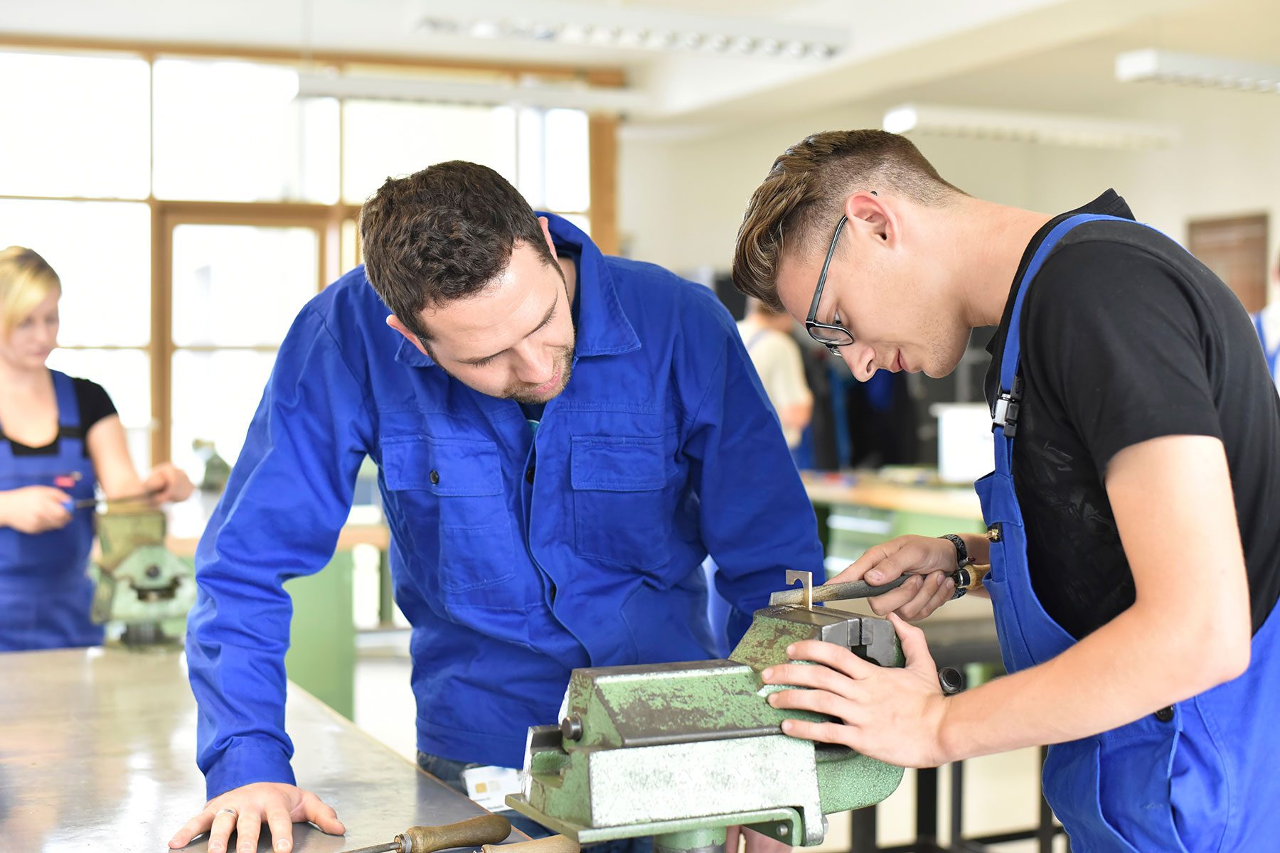 Instructor with trainee at workbench