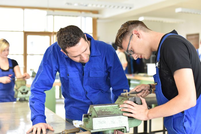 Instructor with trainee at workbench