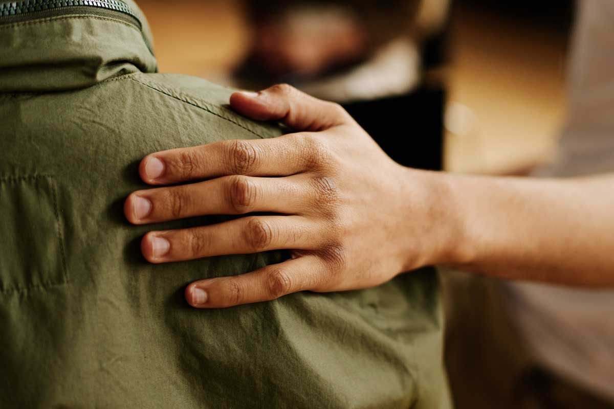 Hand Of Young Supportive Man Consoling His Friend With Post Traumatic Syndrome