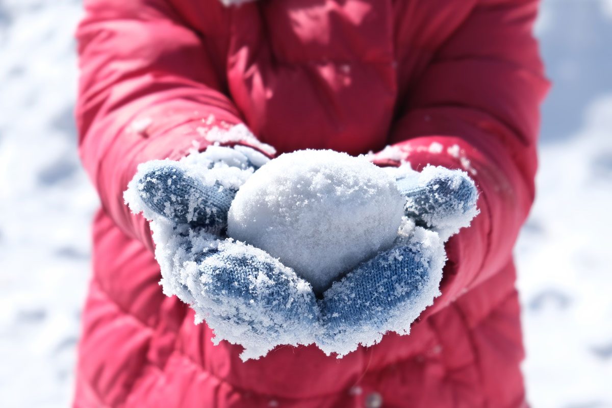 Snowball In Frosty Mittens On The Hands Of A Child