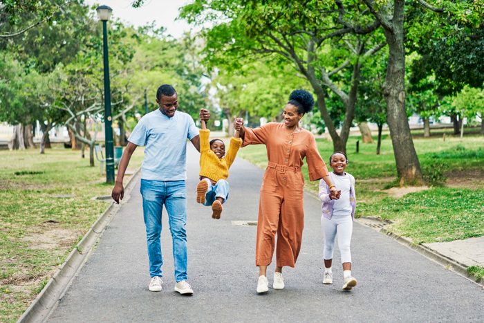 Family On Walk In Park Holding Hands And Laughing Together In Nature Gettyimages 1469742405 Ksedit