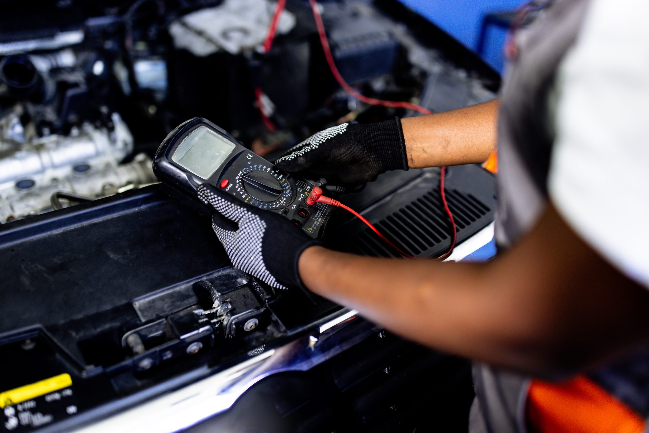 Auto electrician troubleshooting a car engine