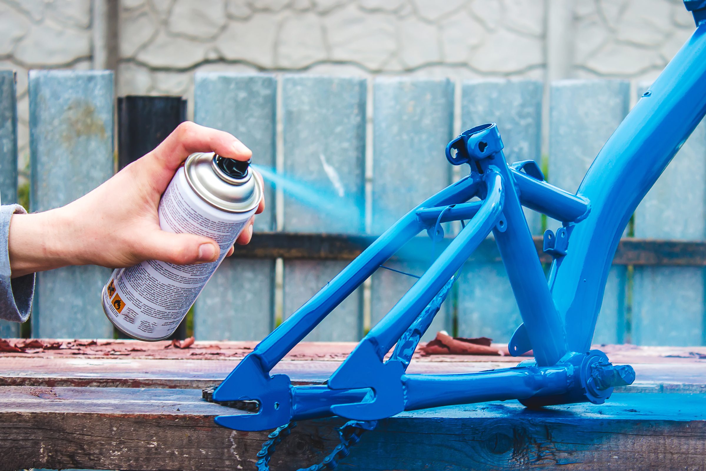 spray painting a bike blue outside