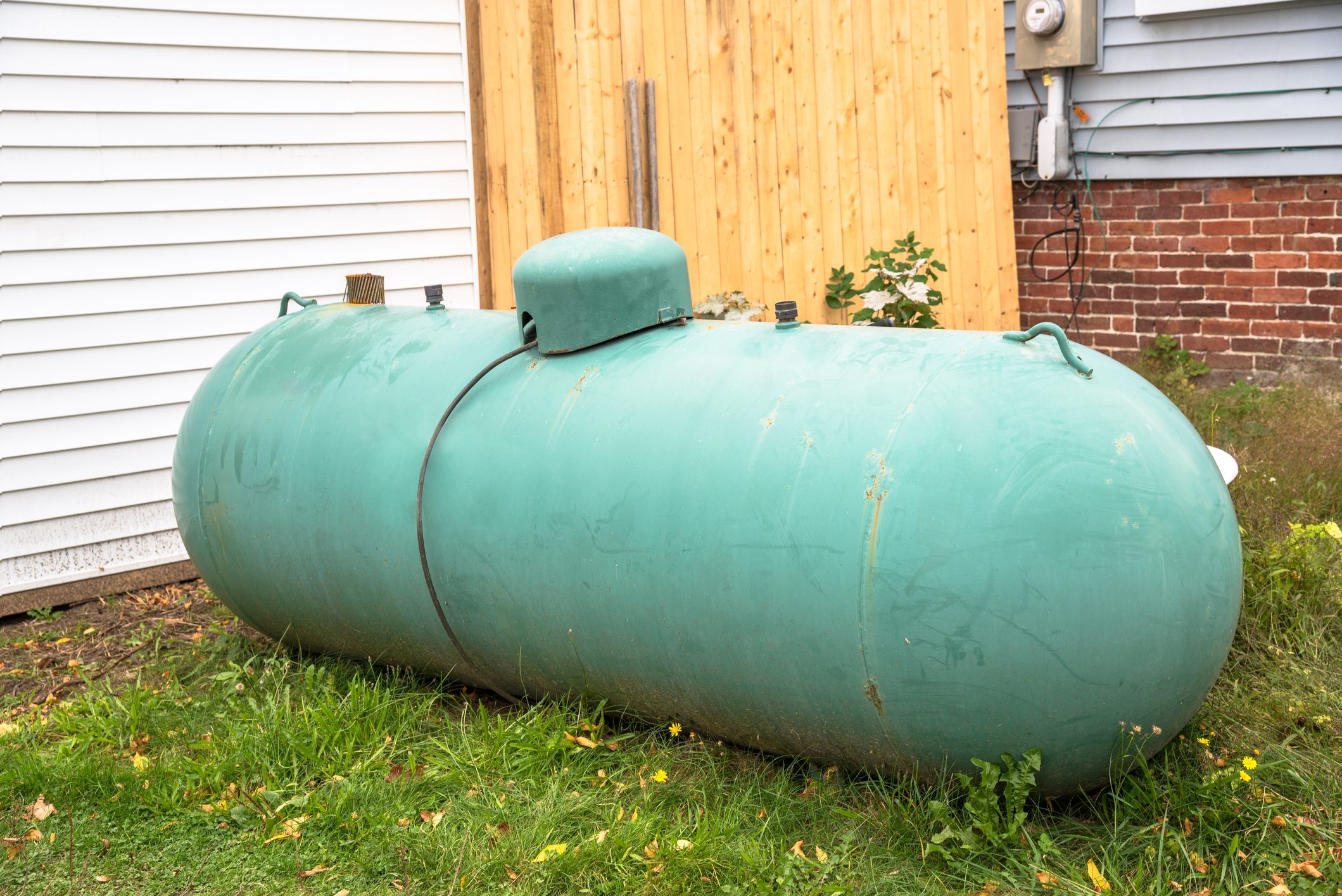 Old large propane tank in the backyard of a house