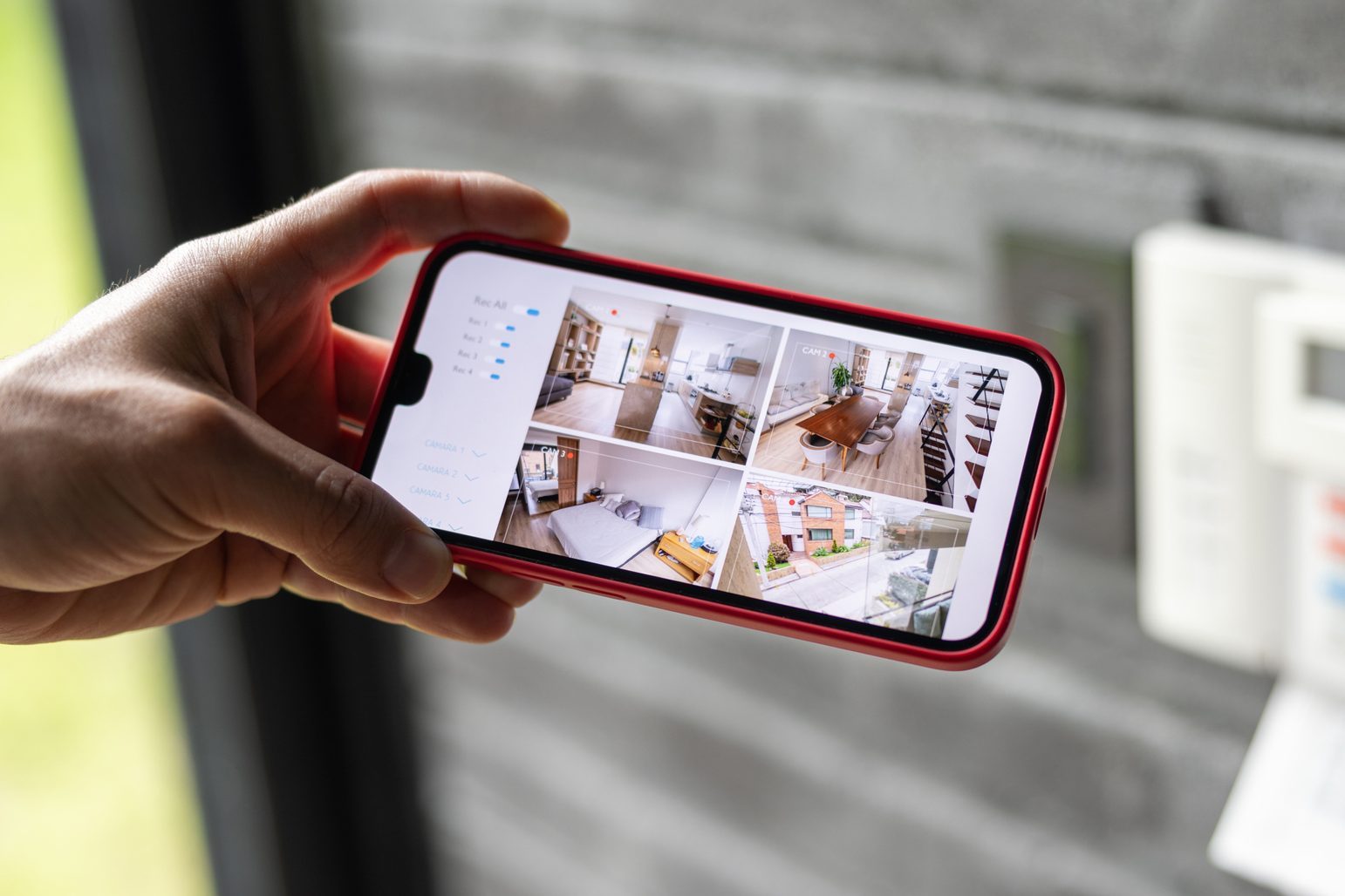 Man watching the security cameras of her house in her cell phone