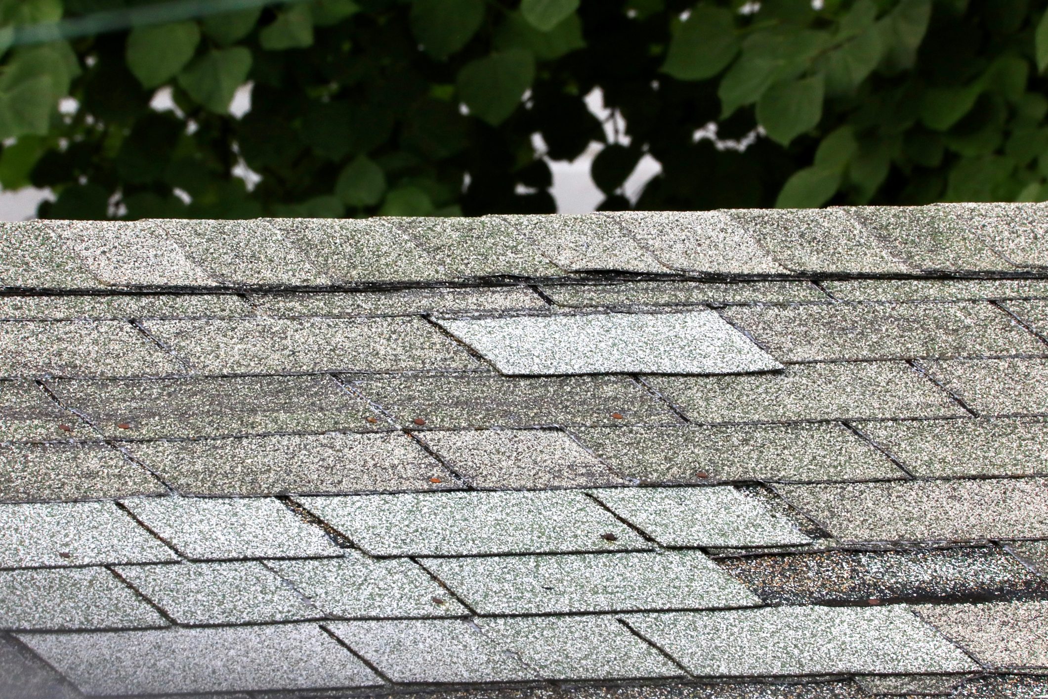 Damaged roof With replacement shingles