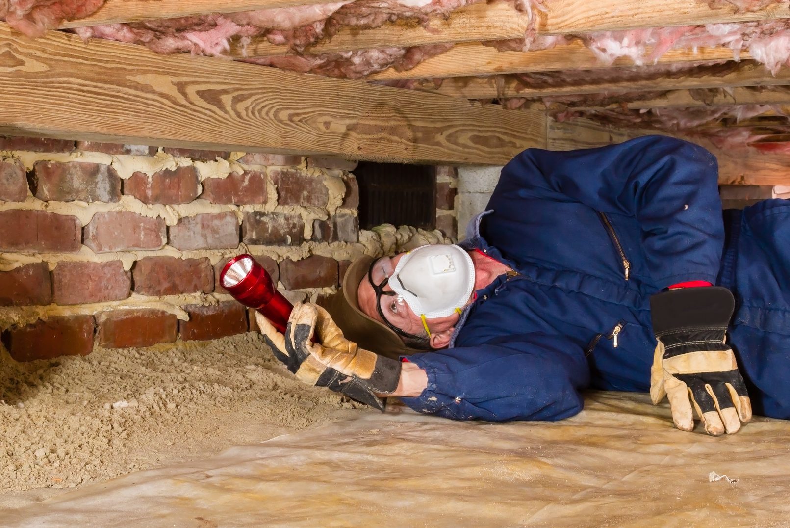 Man inspecting for termites in crawl space