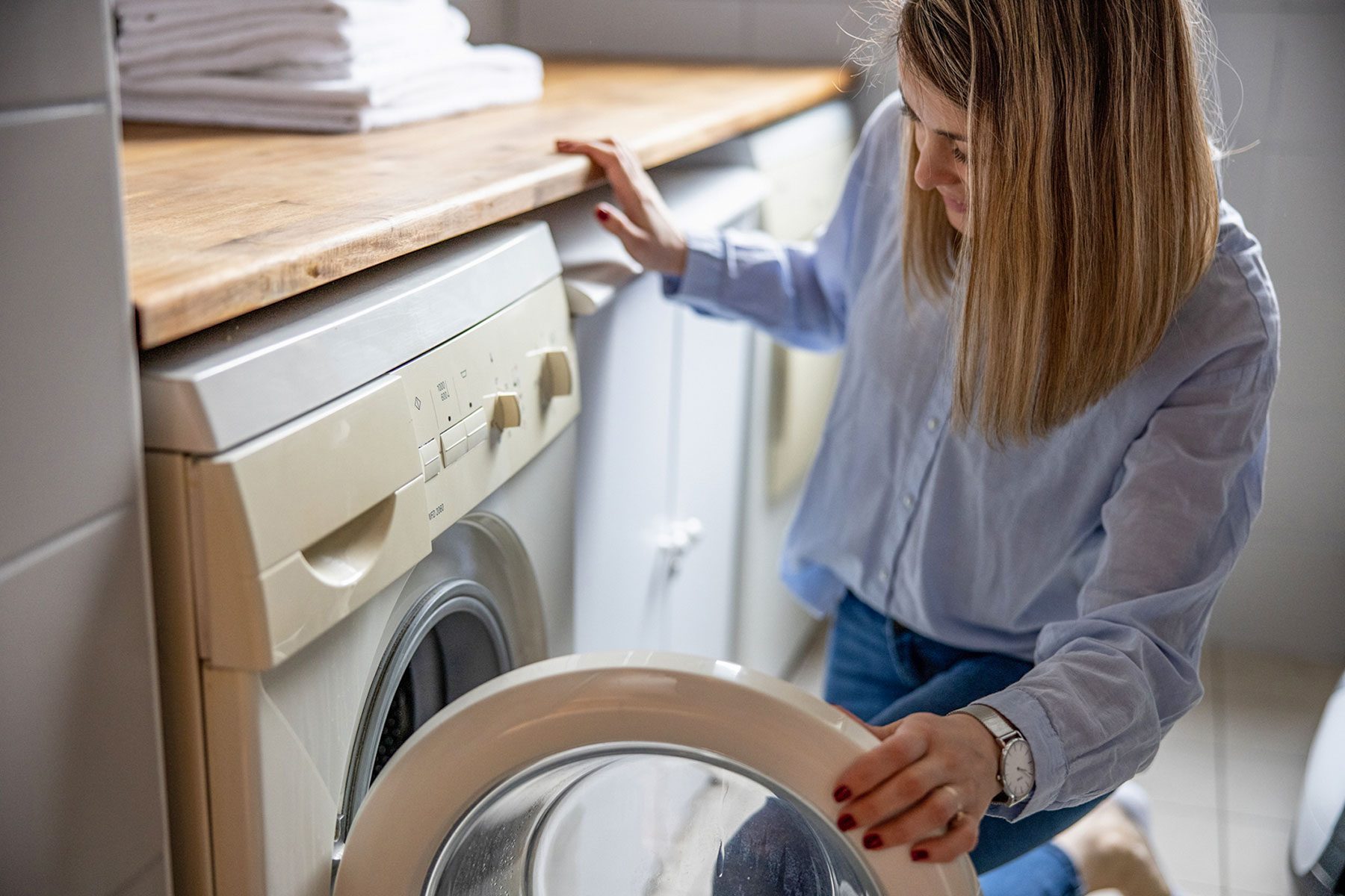 Woman Taking Clothes Out From Washing Machine