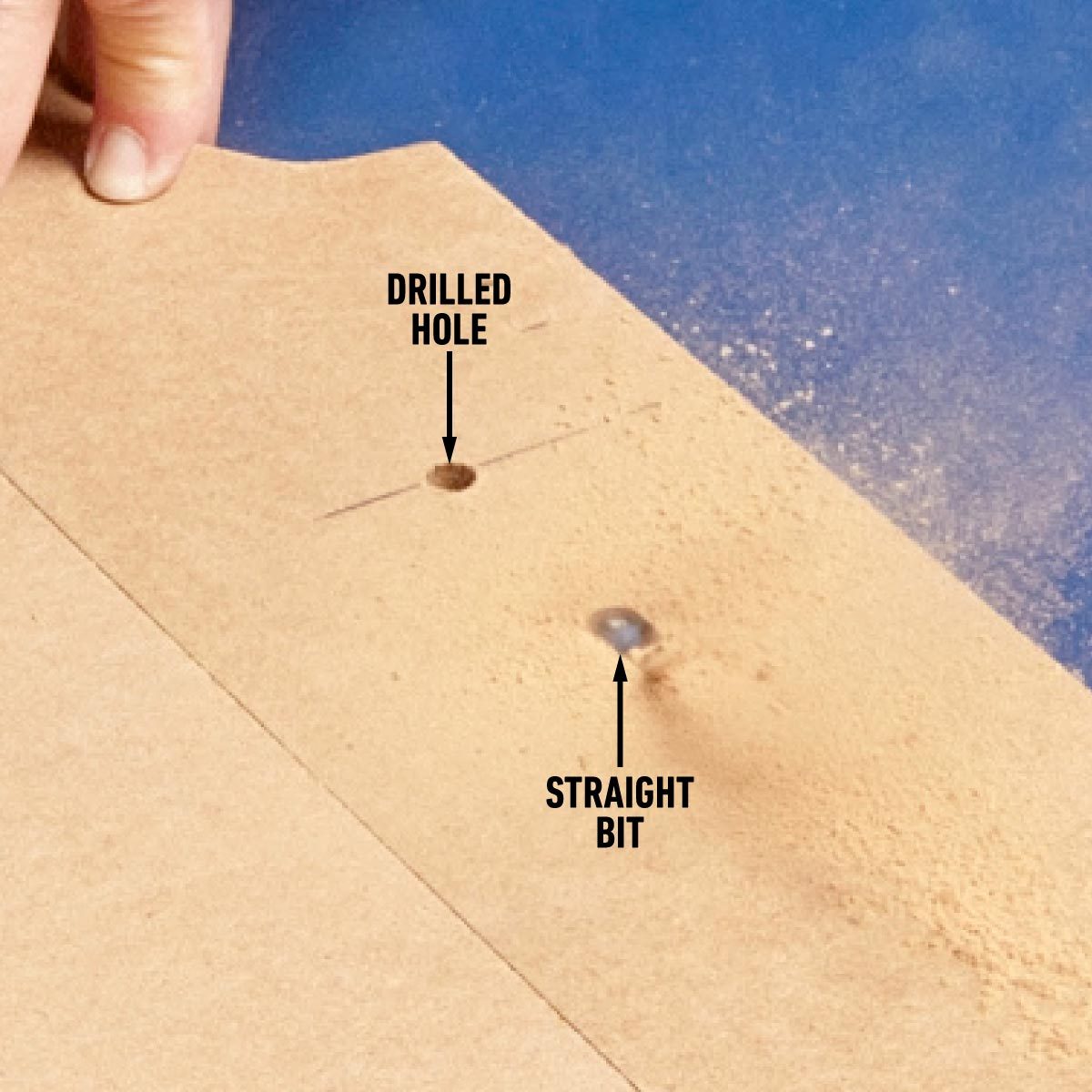 A person cutting two holes in a piece of fence.