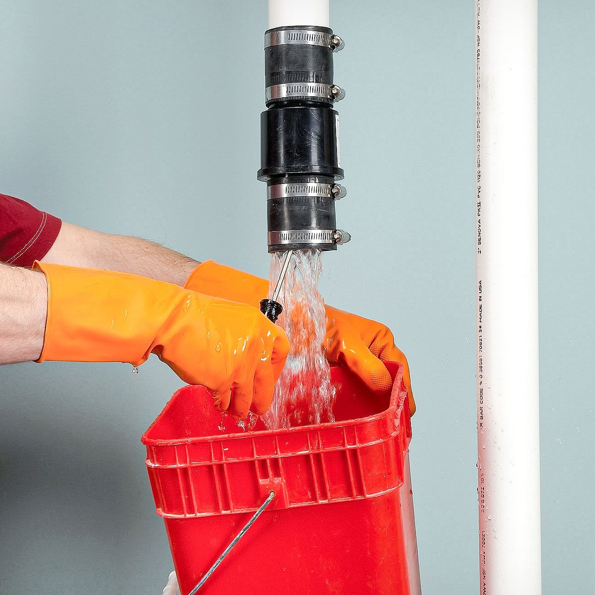 Pushing A Long Screwdriver Up Into The Check Valve To Drain The Water Above The Valve Into Plastic Bucket