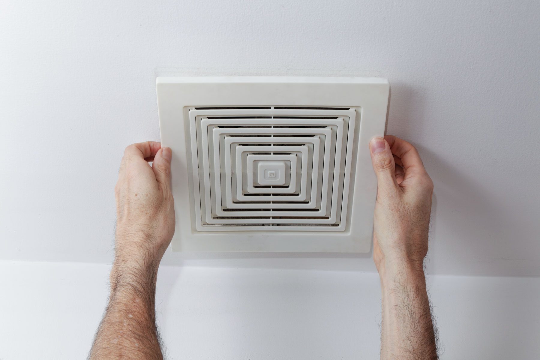 A man setting up the exhaust fan
