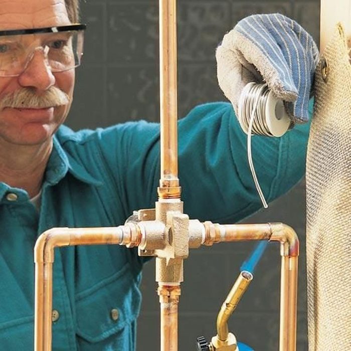 A man working on a copper pipe