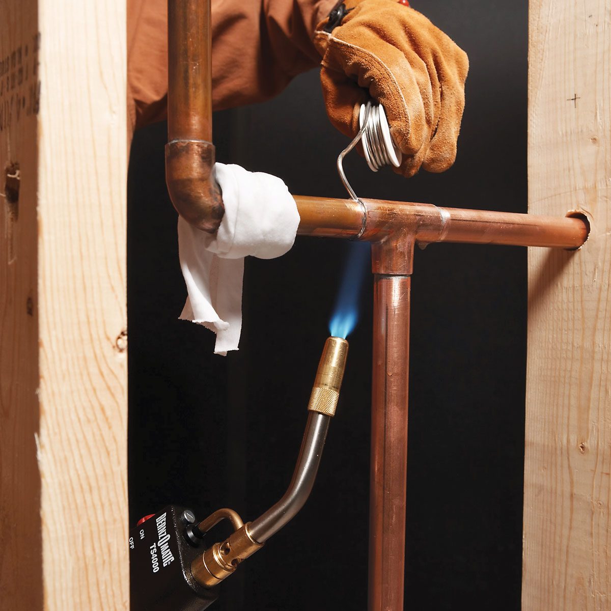 A person welding copper pipe