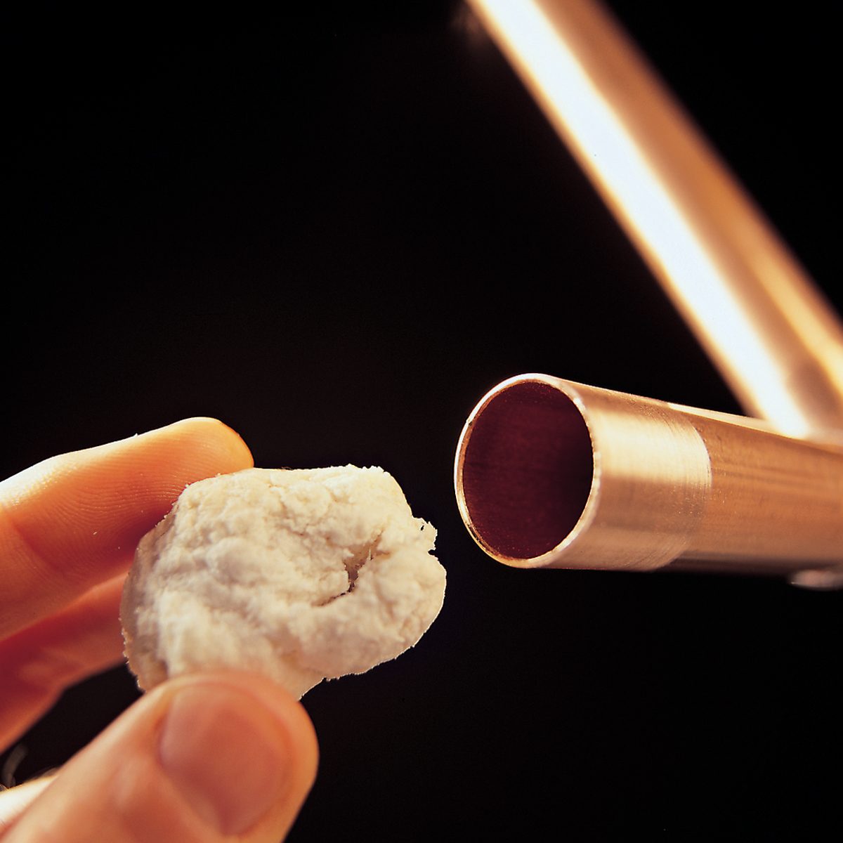 A close-up of a hand holding a piece of white material.