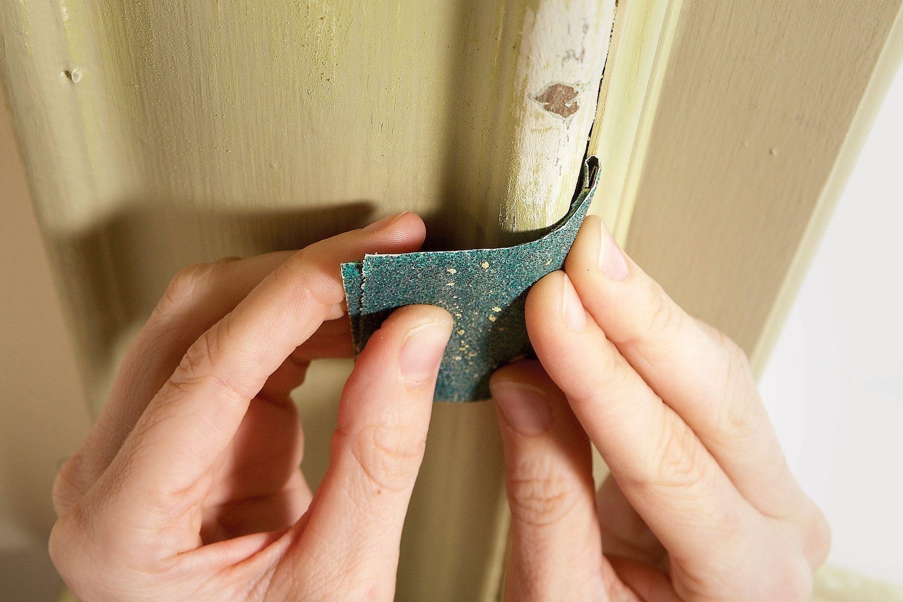 A person using sandpaper on a pipe