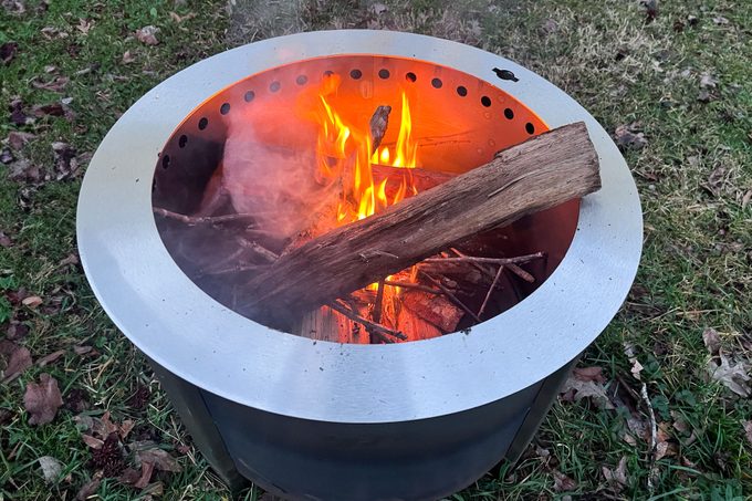 Burning wood in side the breeo stove in the backyard
