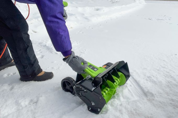 A woman cleaning snow with Earthwise Electric Snow Shovel