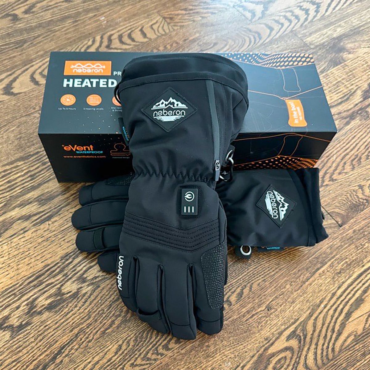 Neberon Heated Gloves lwith box lying on wooden surface