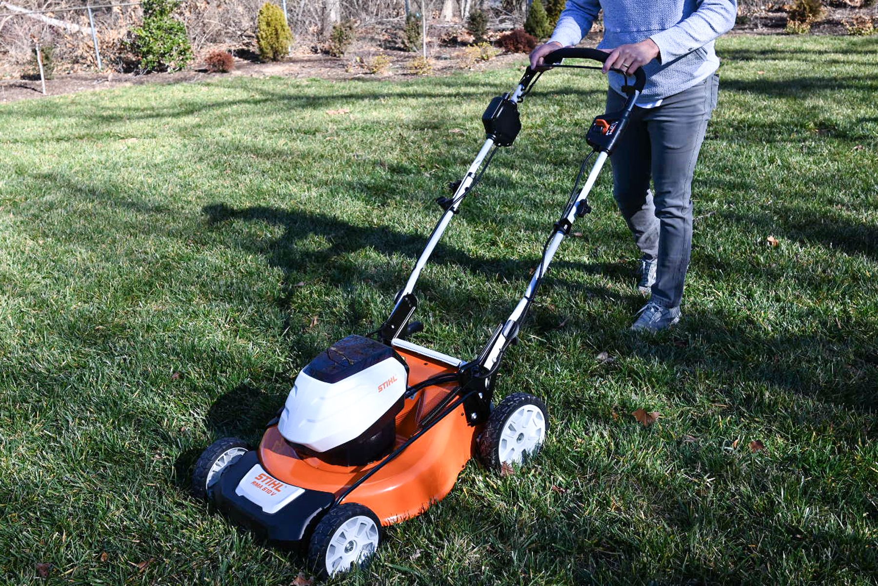 A person cutting grass through Electric-Mower