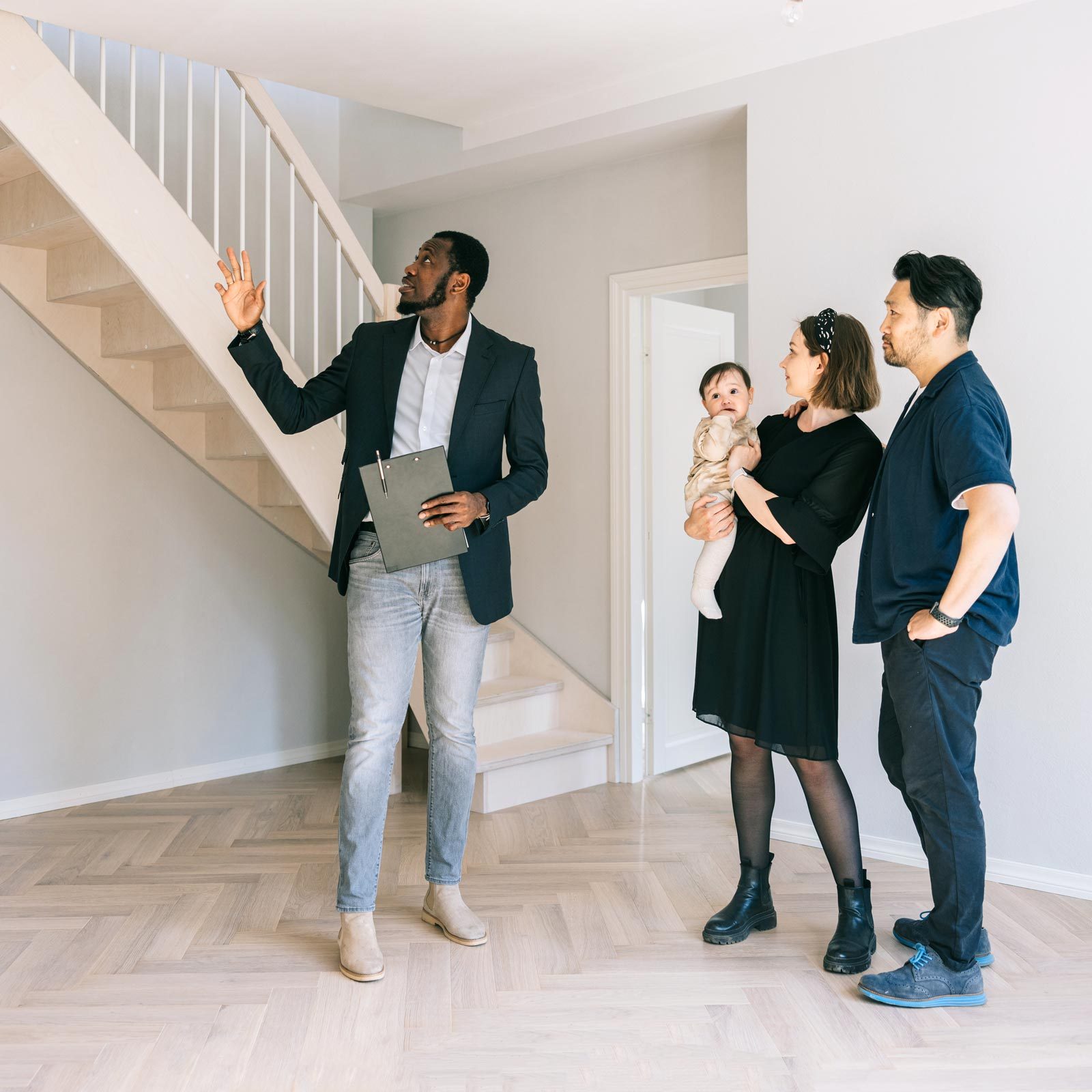 husband and wife with baby recieving an estimate from a man on how much it'll cost to make home into an income property