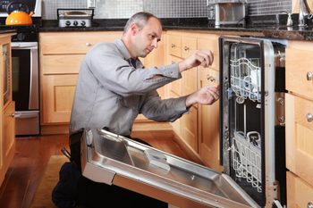 man fixing the seal on a dishwasher to prevent it from leaking