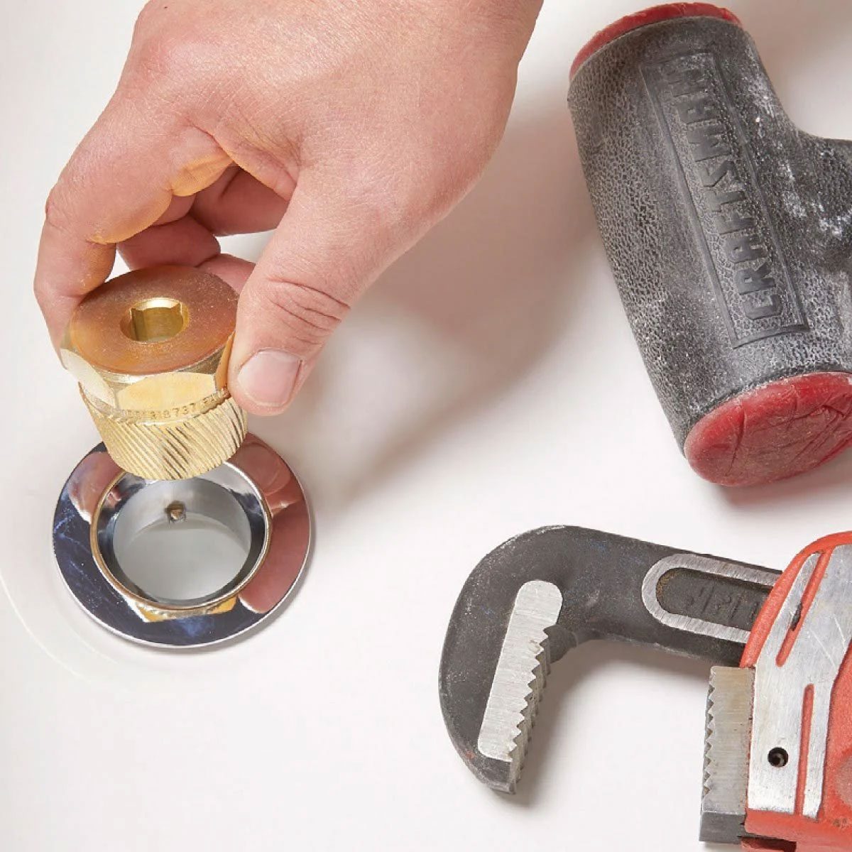 Loosening A Bathtub Drain Using A Drain Extractor With A Hand