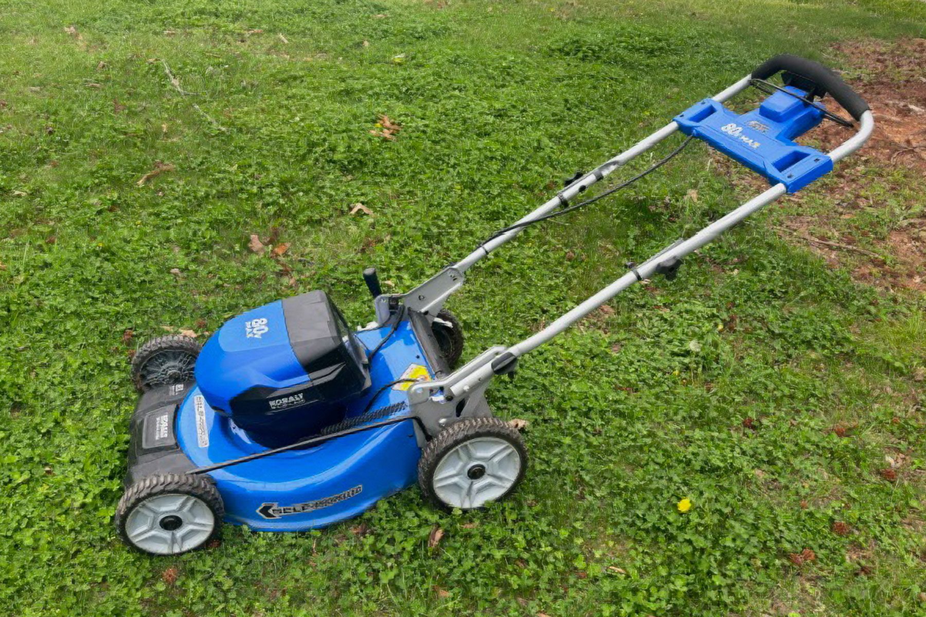 Electric mower cutting grass on the front yard