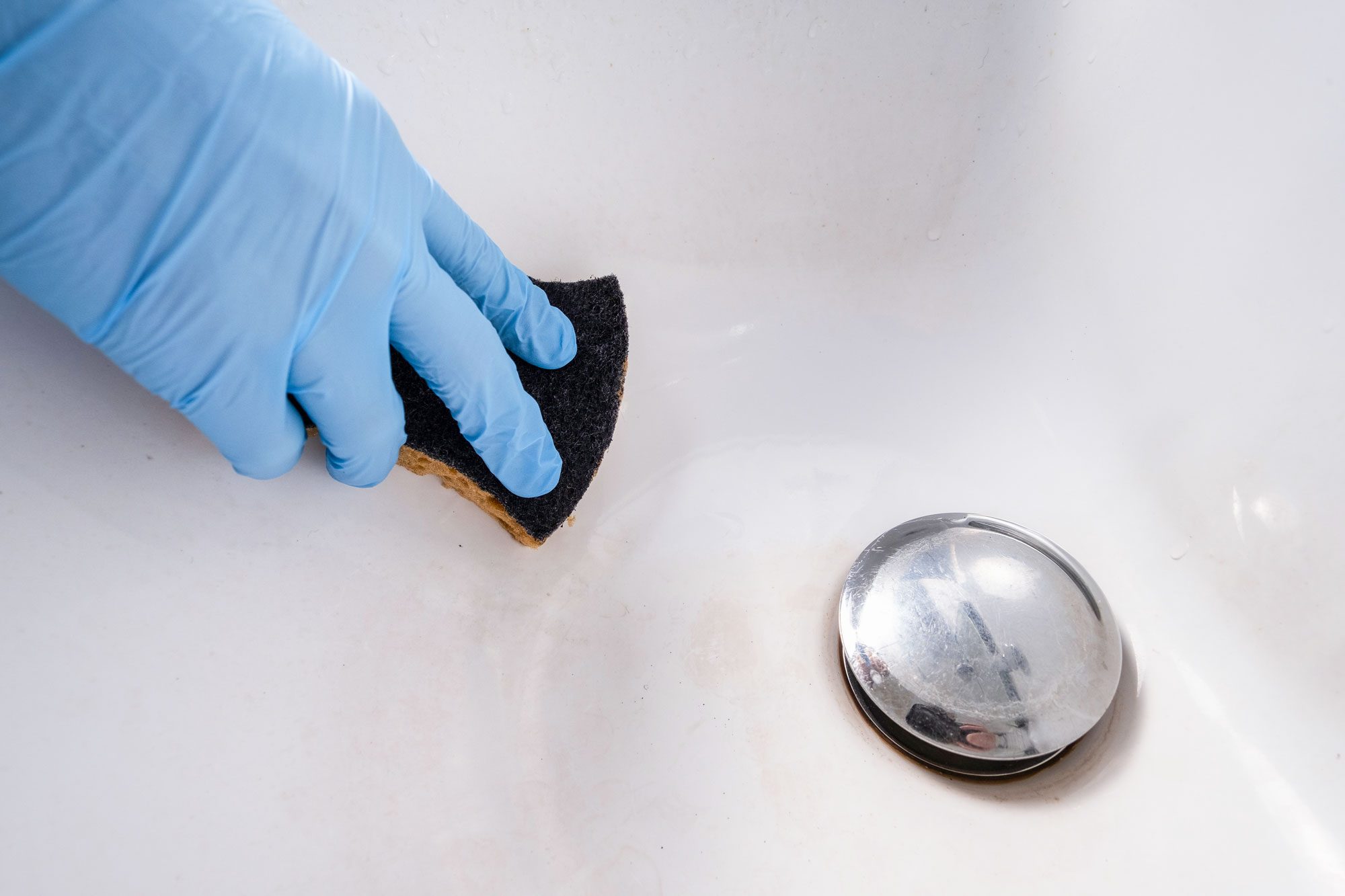 Hand In Latex Protective Gloves Cleaning Bathrub With Sponge