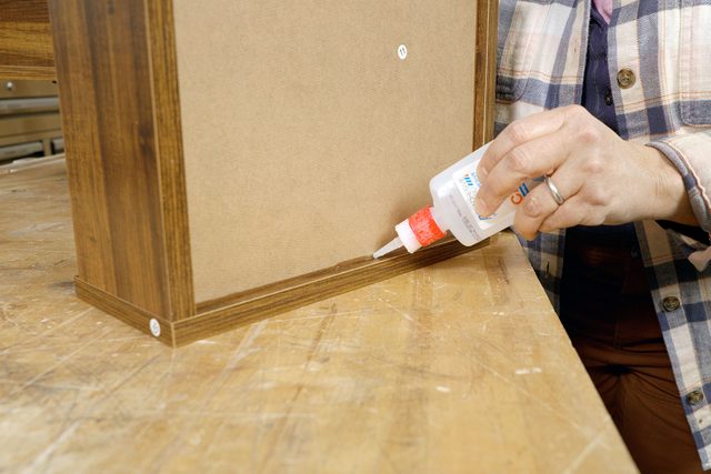 Applying glue on wooden surface