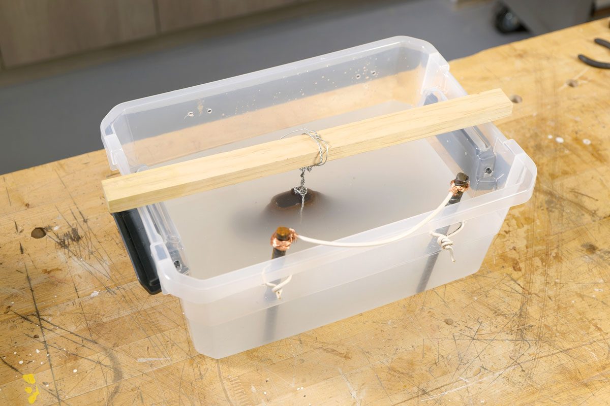 Suspend rusty item in electrolyte solution