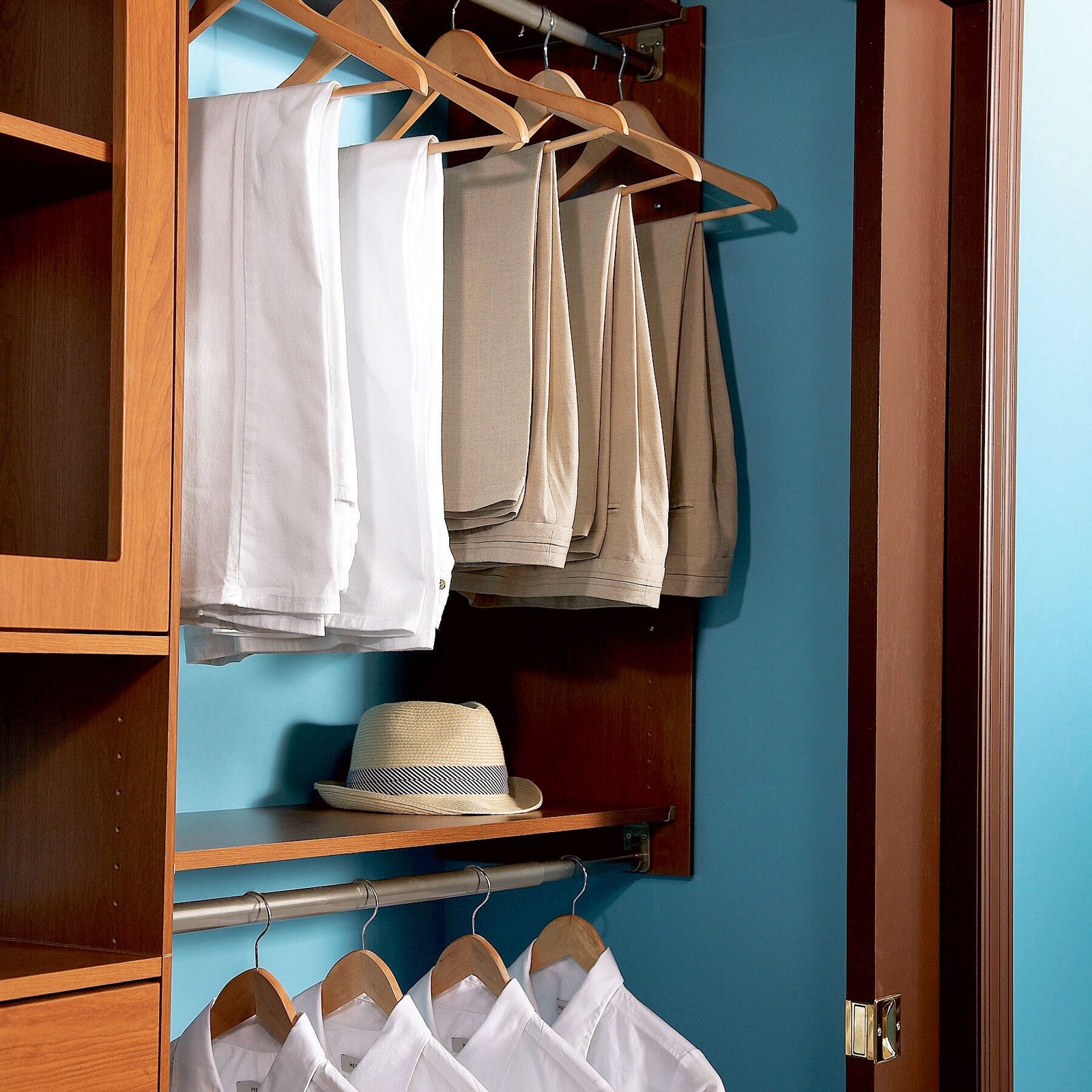 organized closet system with pants hanging above shirts