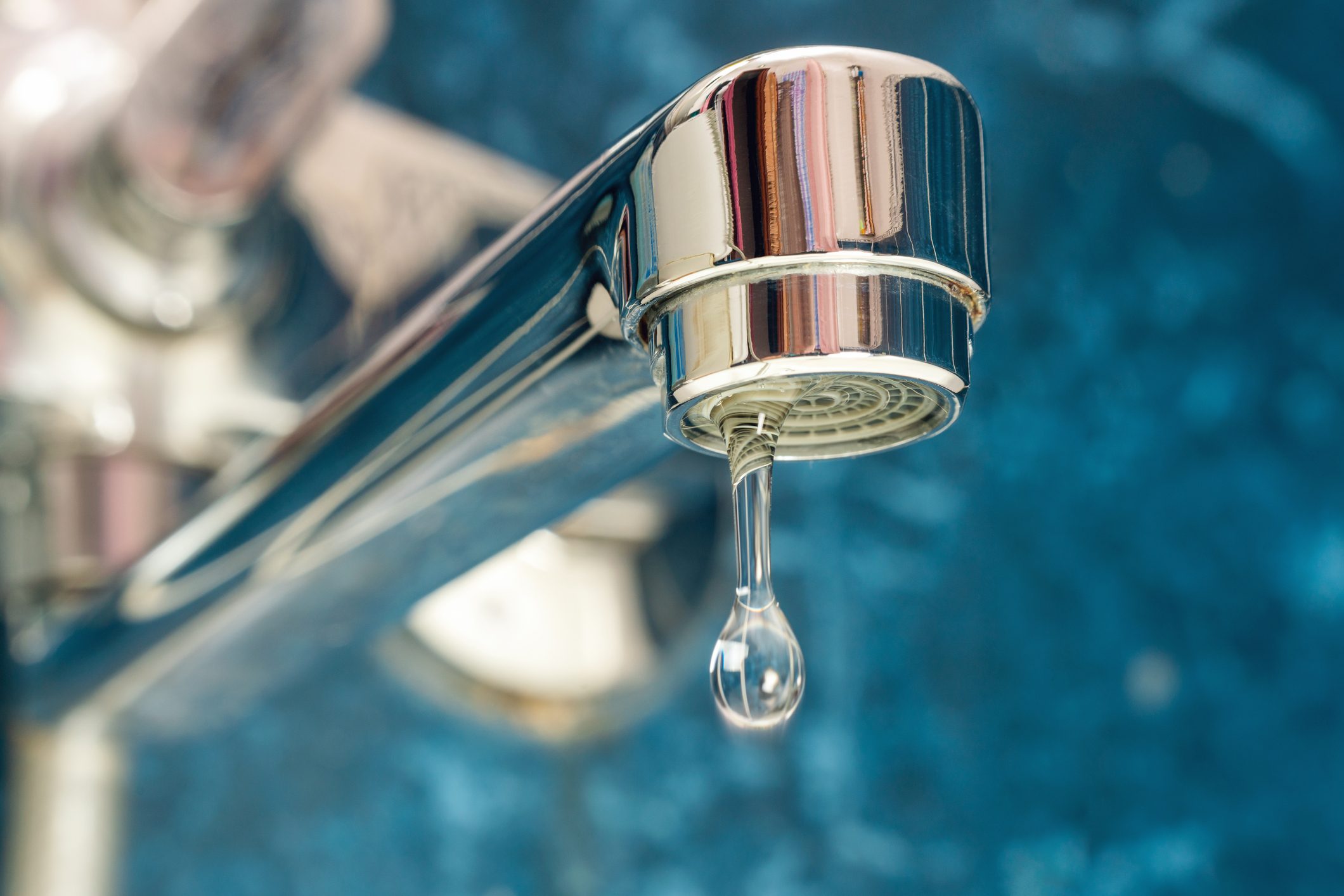 A drop of water drips from a leaky faucet