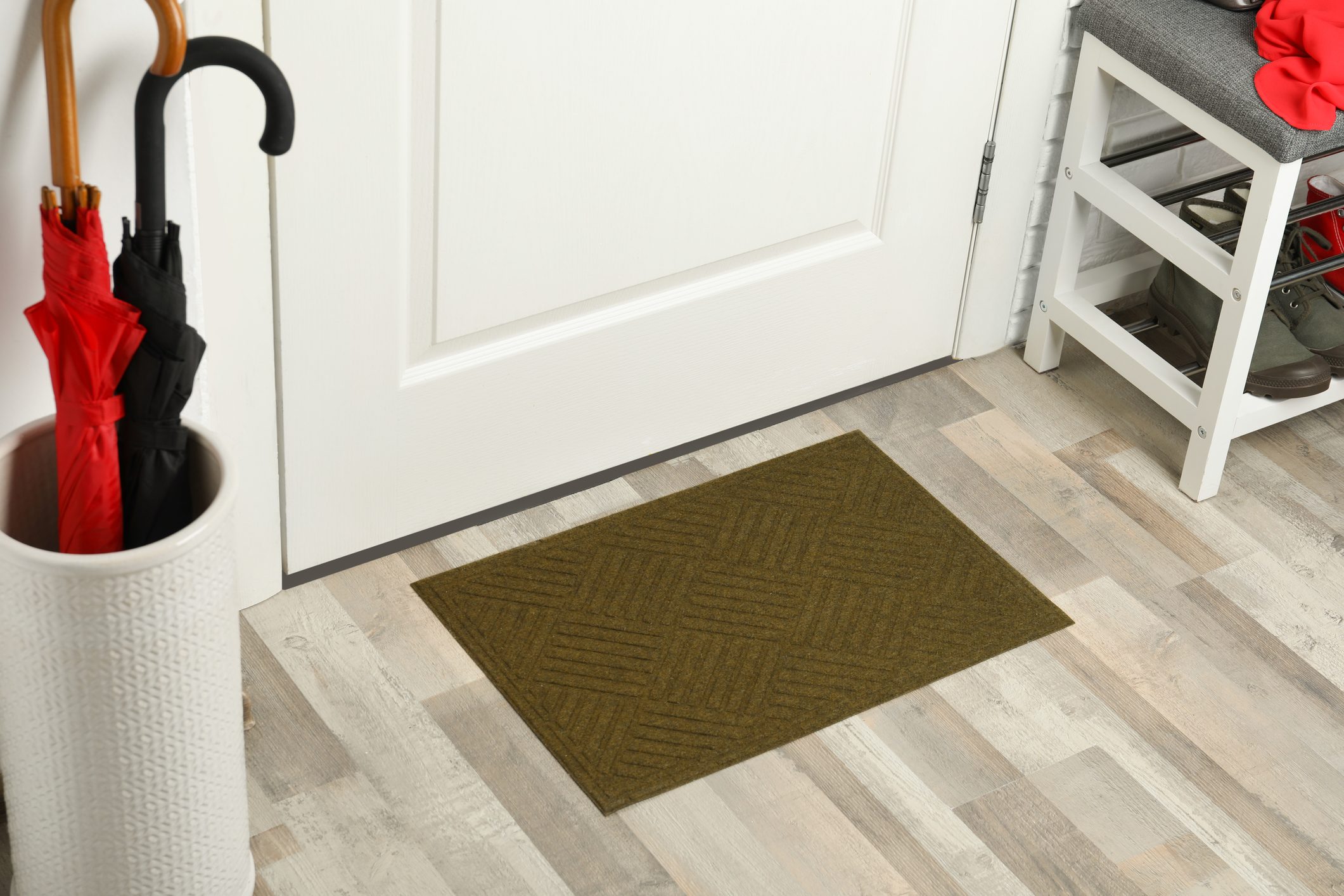 Clean door mat on wooden floor in hall