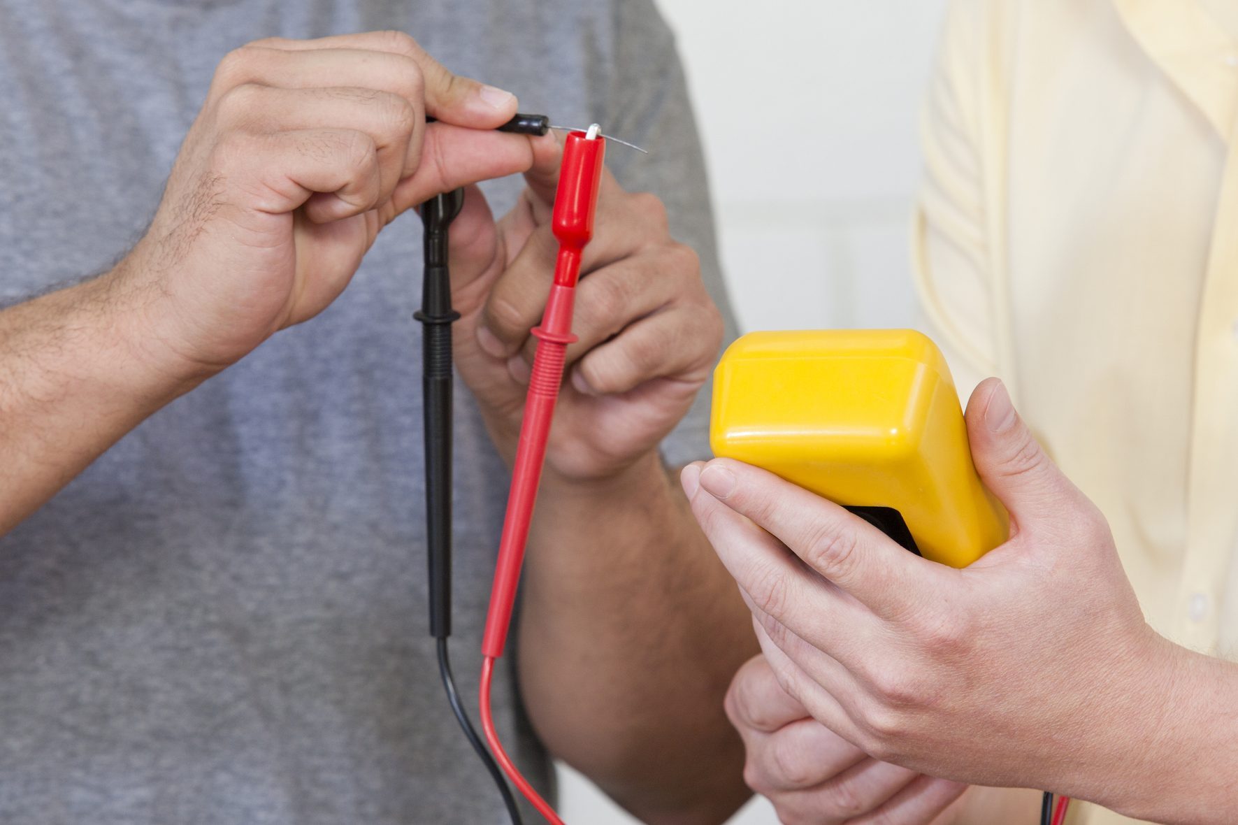 Engineering students measuring resistor using multimeter