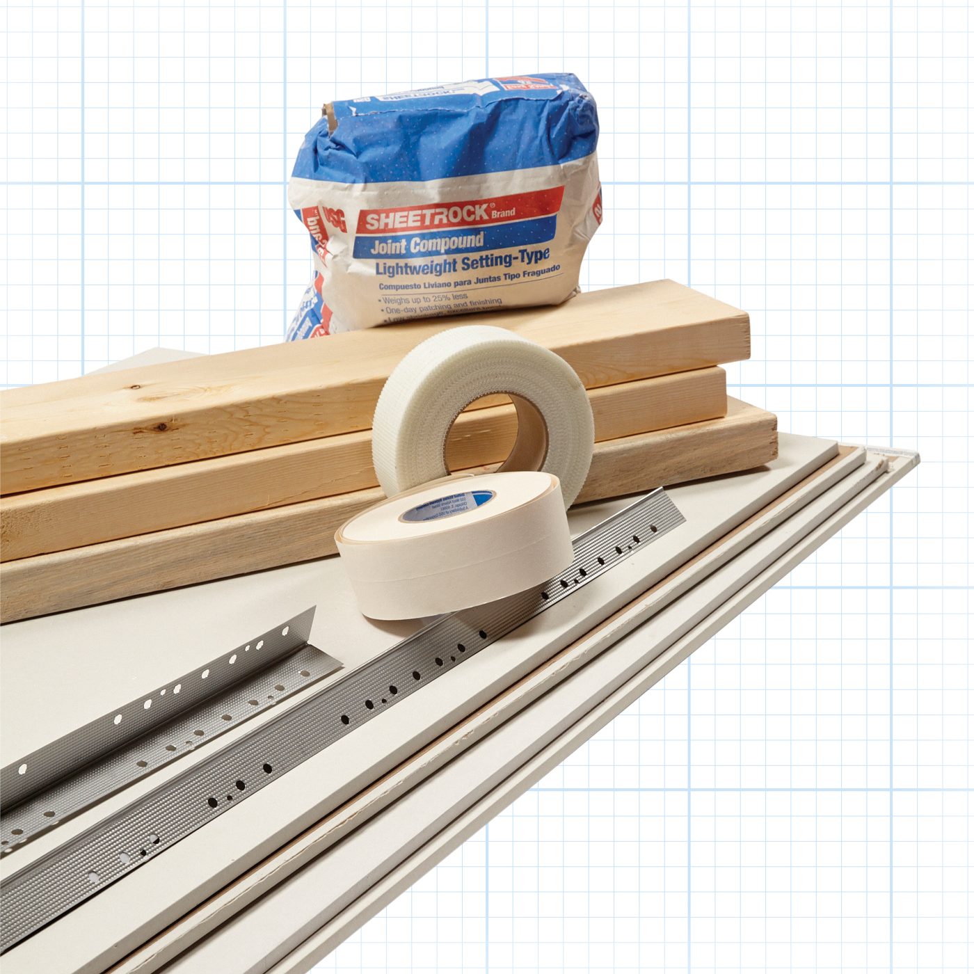 A stack of construction materials including wooden planks, rolls of drywall tape, a packet of Sheetrock joint compound, and several pieces of drywall arranged against a grid-patterned background. A metal corner bead is also visible.