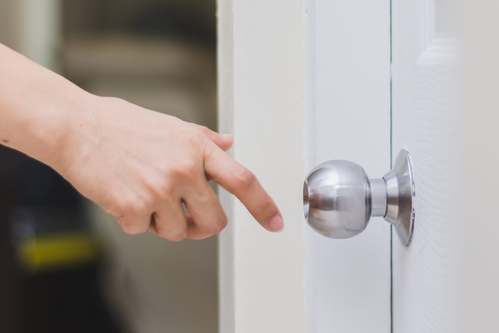 Close up of woman’s hand reaching to door knob getting static shock