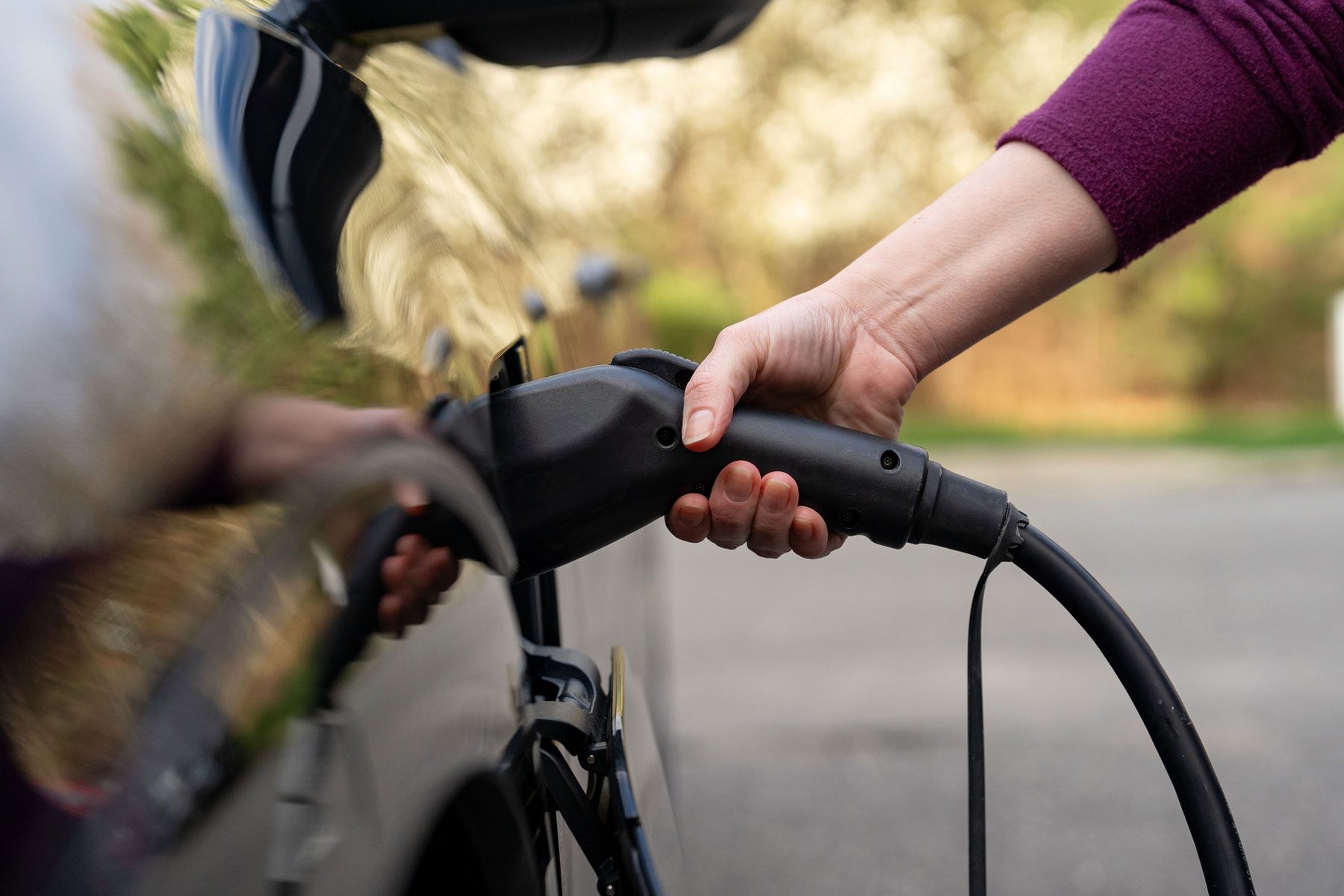 woman charging an electric vehicle at home