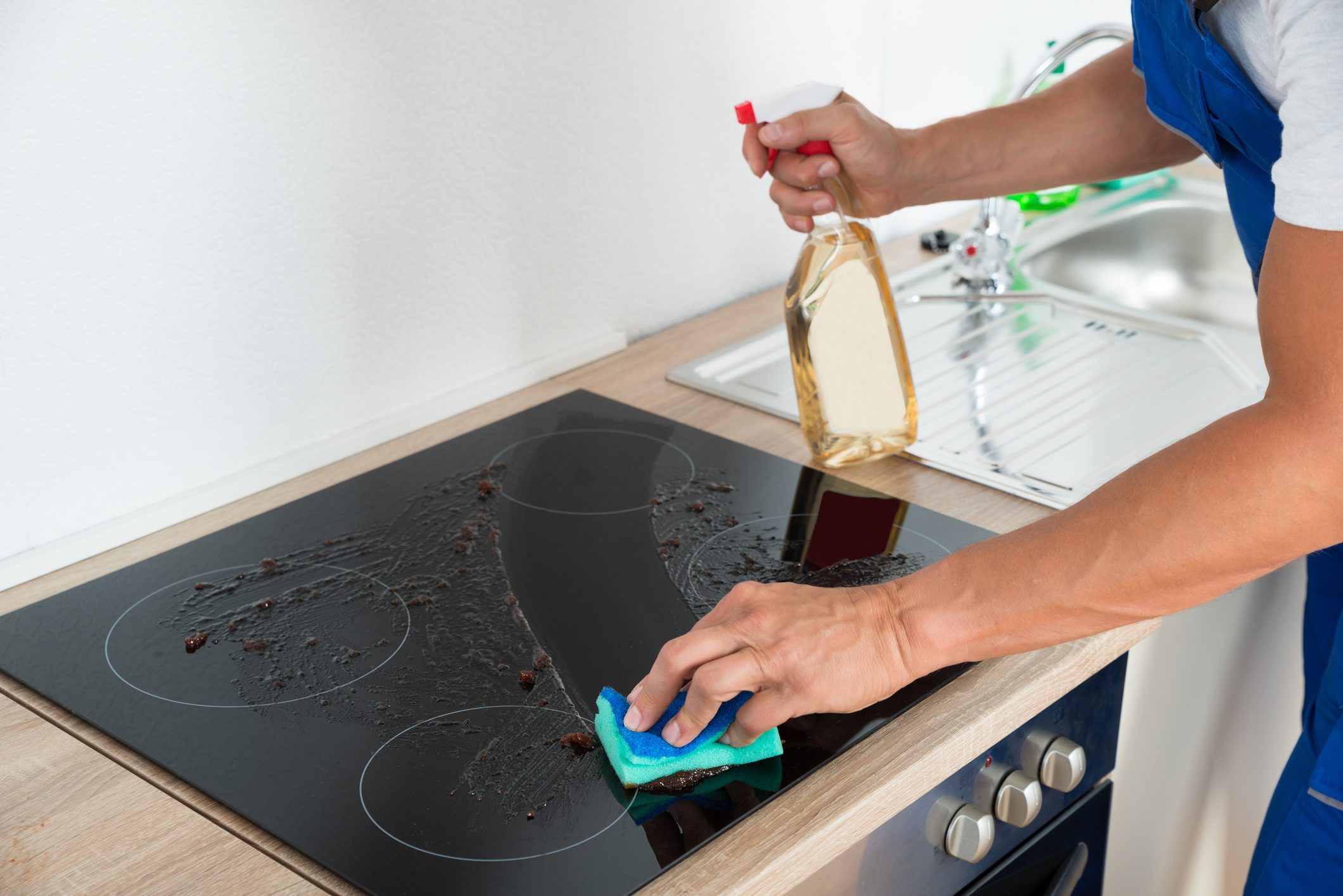 Janitor Cleaning Induction Stove In Kitchen