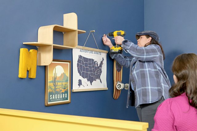 woman installing things on gallery wall