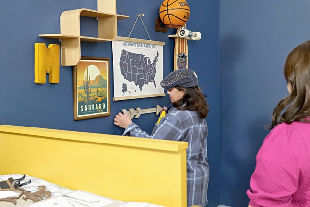 woman installing things on gallery wall