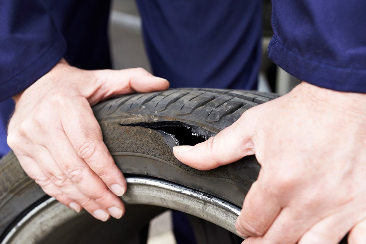 mechanic examining damaged car tire