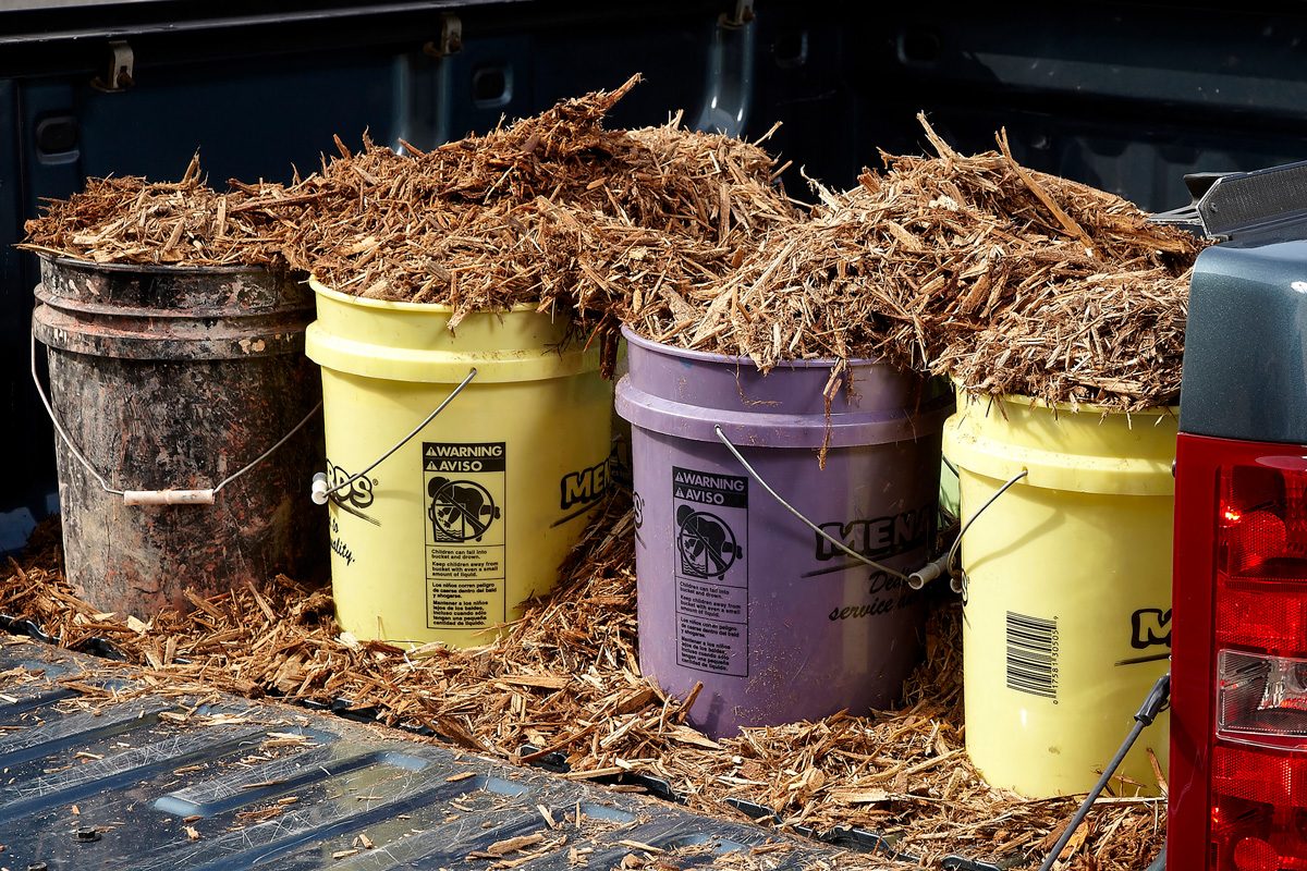 buckets in the back of a vehicle filled with mulch