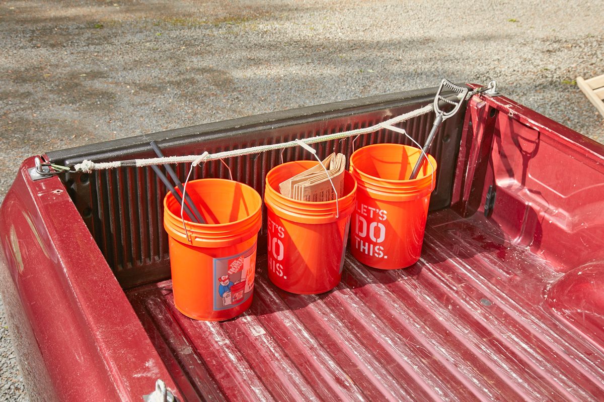 buckets in the back of a vehicle held together by bungees