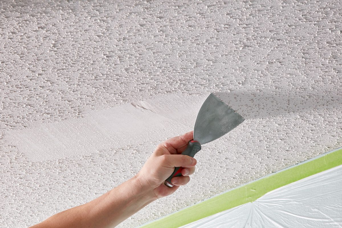 person scraping popcorn ceiling