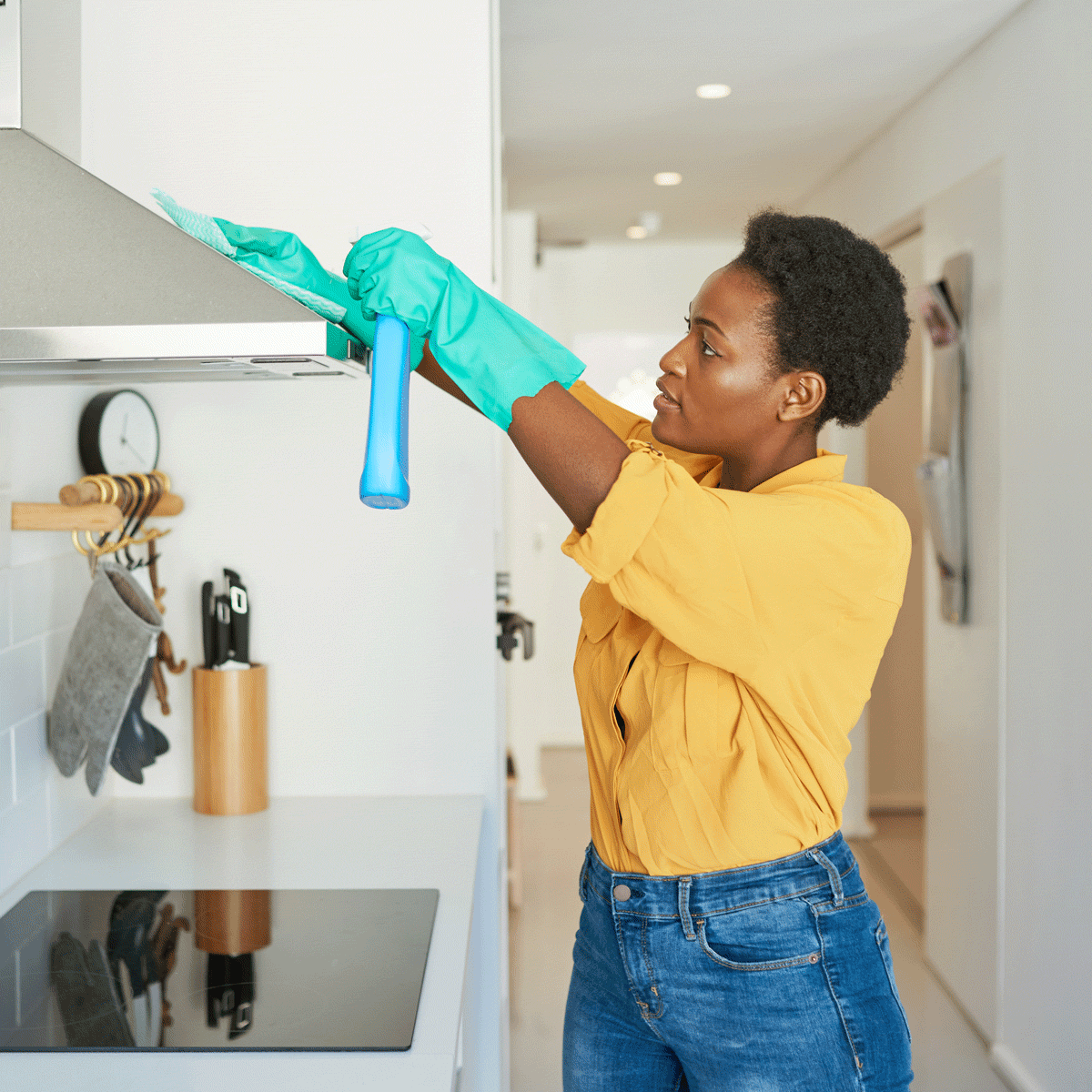 Woman cleaning the range hood in her kitchen