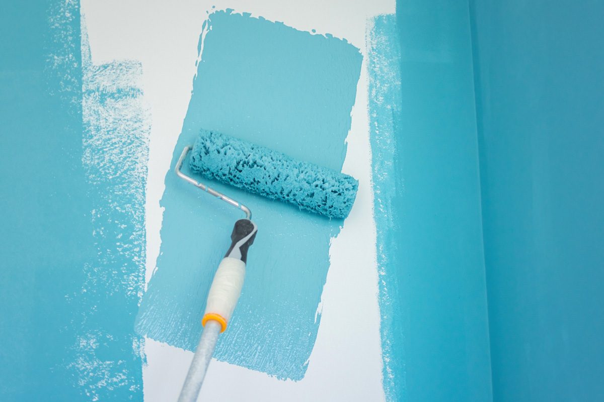 painting a wall with blue paint